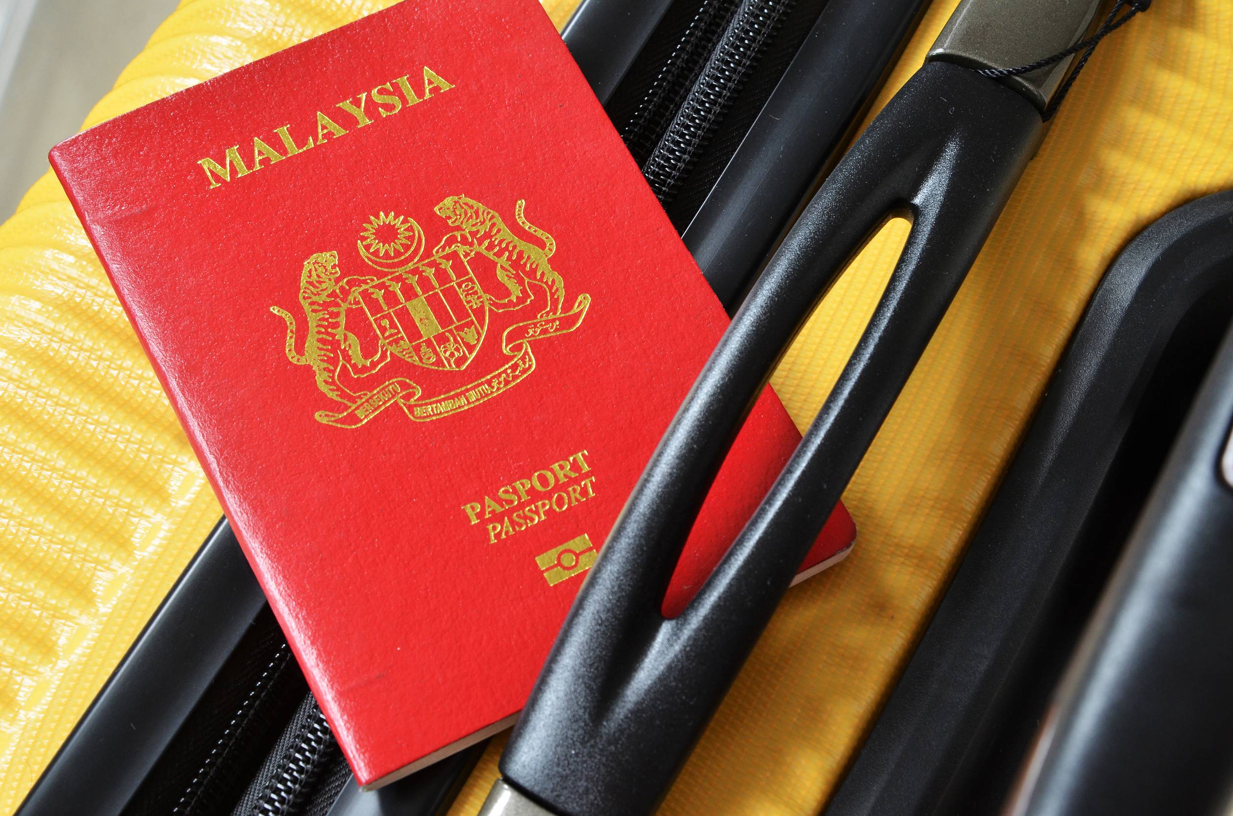 Malaysia Passport On A Yellow Suitcase Travel